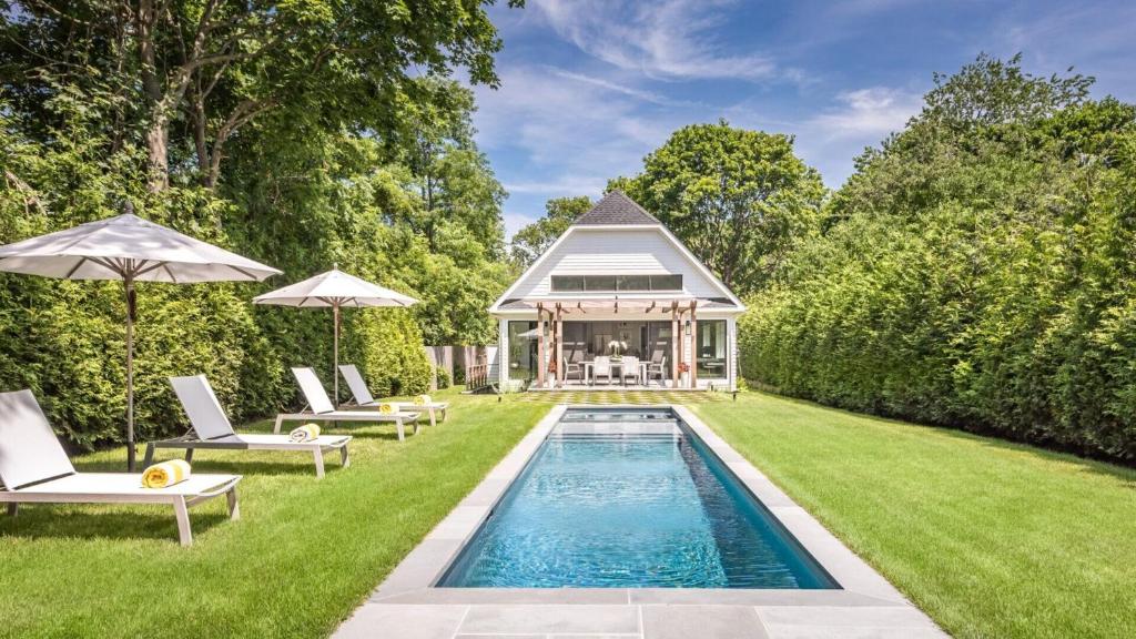 a swimming pool in the yard of a house at Villa Mist Manor in East Hampton