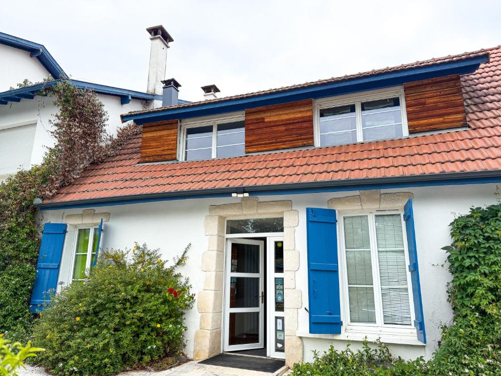 a house with blue doors and a red roof at Le Domaine de Rose in Lourdes