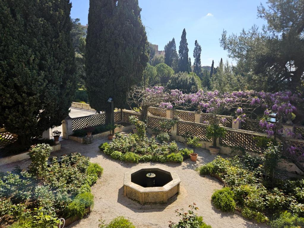 a garden with a fountain and some flowers and trees at Le Finestre su Villa d'Este in Tivoli