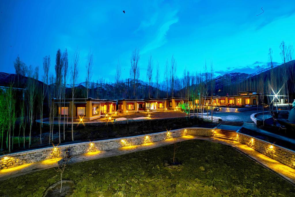 a building with lights in a yard at night at Royal Soma Resort in Stak