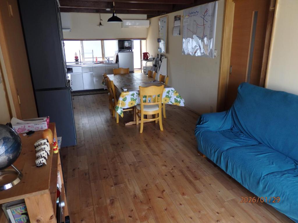 a living room with a blue couch and a table at Guesthouse ONE WORLD 一棟貸の宿 in Kitsuki