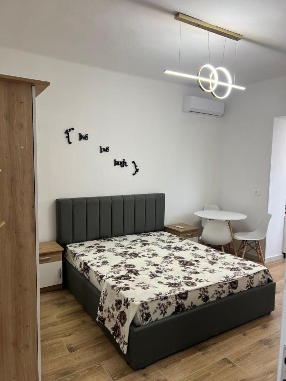 a bedroom with a bed and a table with chairs at E&B Cosy Apartment 6 in Tirana