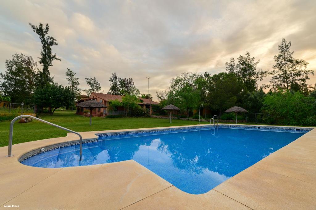 a swimming pool in a yard with a house at Cortijo Zalamea in Zalamea la Real