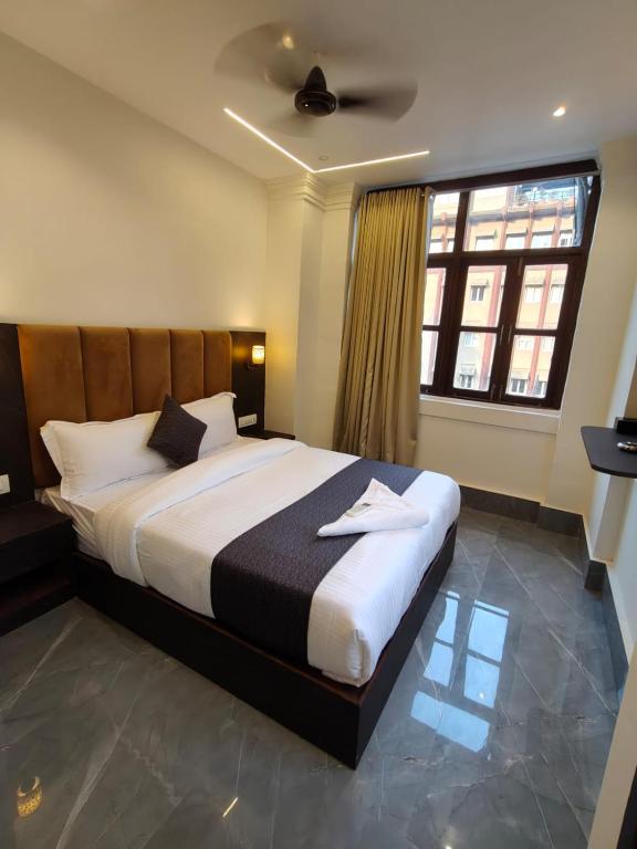 a bedroom with a large bed with a ceiling fan at Hotel Regal Gate in Mumbai