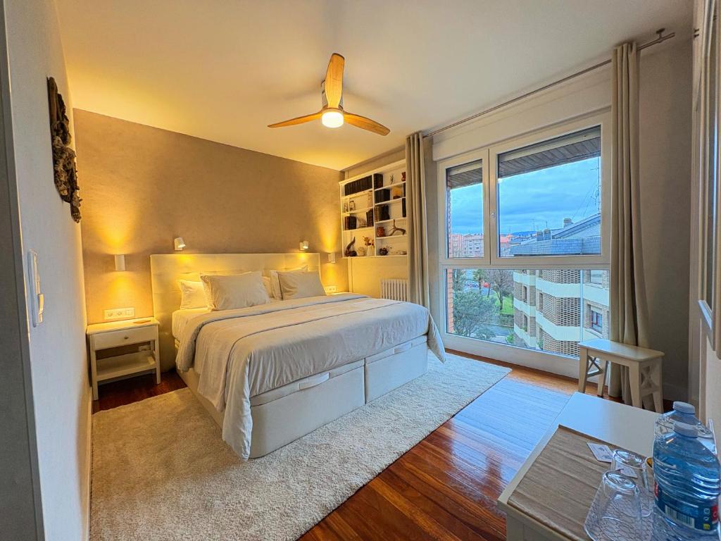 a bedroom with a bed and a large window at Casa Carlini in Getxo
