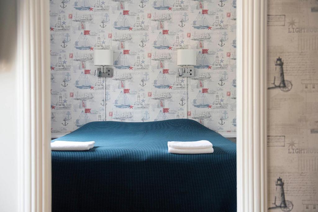 a bedroom with a blue bed with a wallpaper at Drottning Victorias Örlogshem in Stockholm
