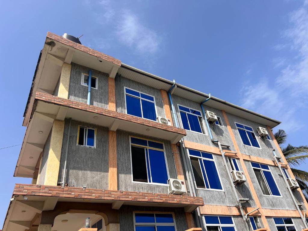 a building with blue windows on the side of it at PhyllenHotel Tanga in Tanga