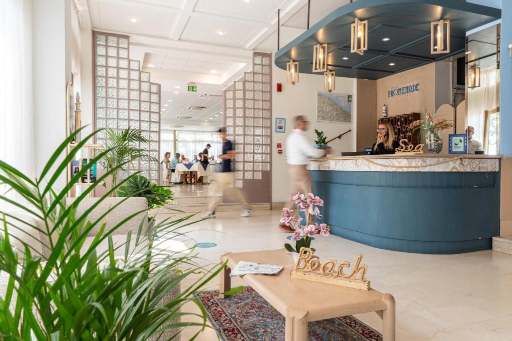 a lobby with a bar with people in the background at Amadei Hotel Promenade in Pesaro