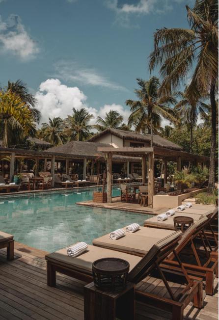 a swimming pool with tables and chairs in a resort at Sempre Vivo in Pipa