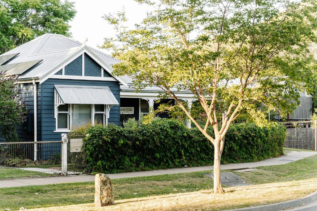 a blue house with a tree in front of it at Corner Cottage Bright in Bright