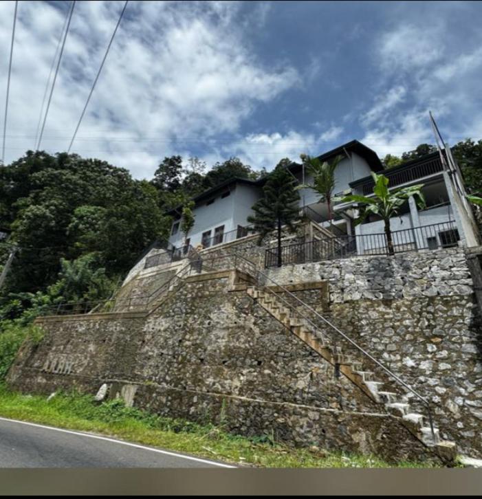 a house sitting on top of a stone wall at Arhh castle in Ginigathena