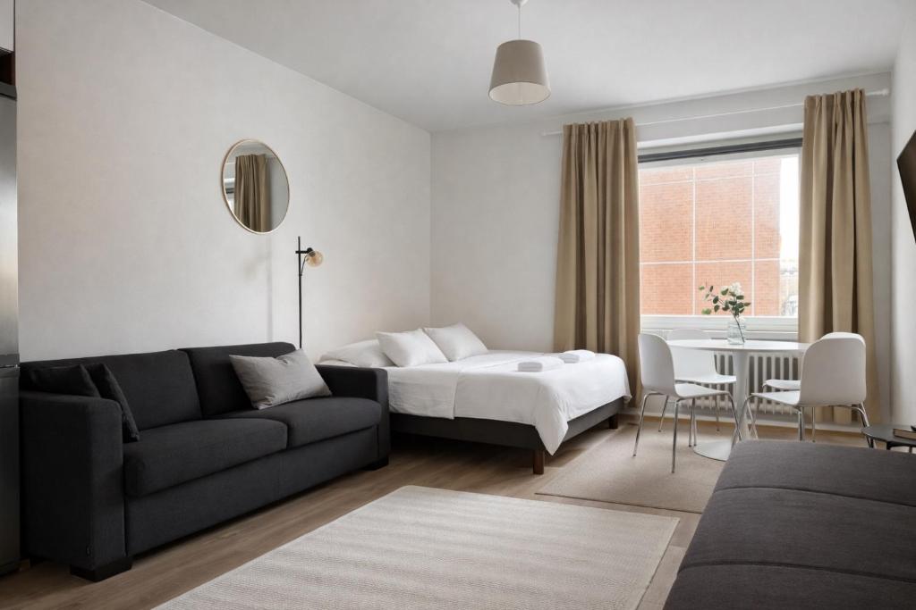 a living room with a bed and a couch at Tammer Huoneistot - City Suite 2 - City View & Perfect location in Tampere