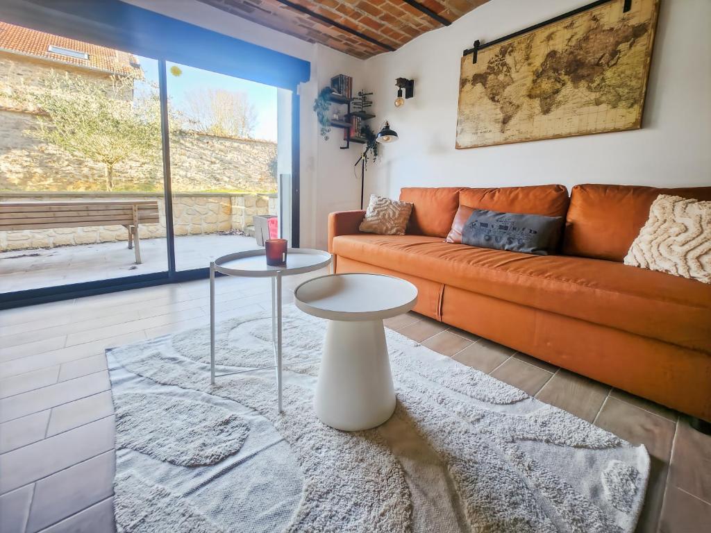 a living room with an orange couch and a table at Appartement Confortable à Coulommiers avec Jardin in Coulommiers