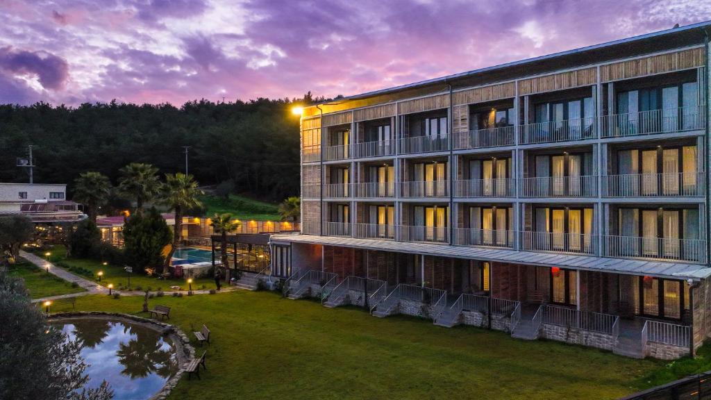 a large building with a lawn in front of it at Garrya Romo Hotel in Urla