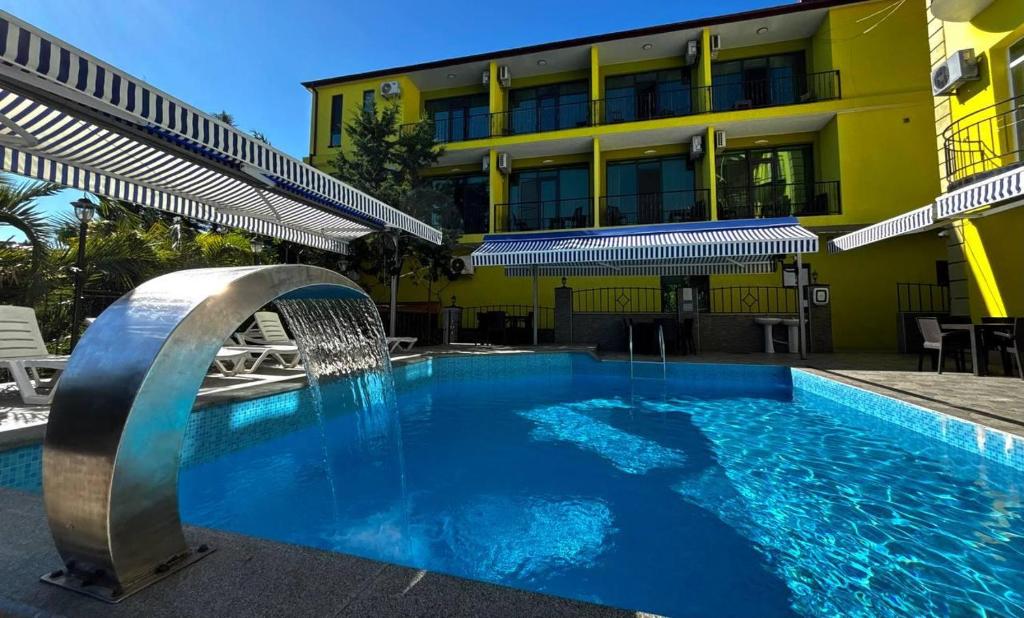 a swimming pool with a fountain in front of a building at DeltaHotel in Ureki