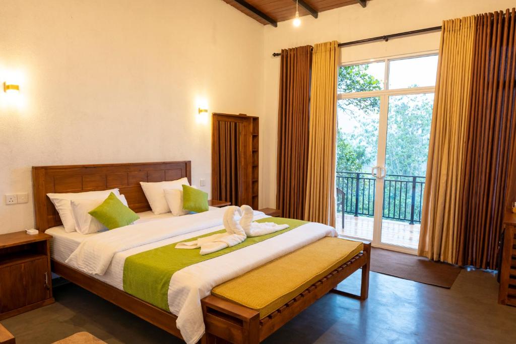 a bedroom with a large bed and a large window at AnuBi Nest Ella in Ella