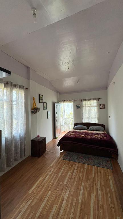 a bedroom with a large bed and a wooden floor at Chotlung BNB in Bijanbāri Bāzār