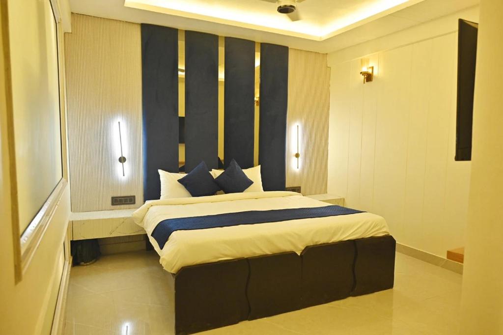 a bedroom with a large bed with blue and white pillows at Hotel Rajmahal Regency in Faridabad