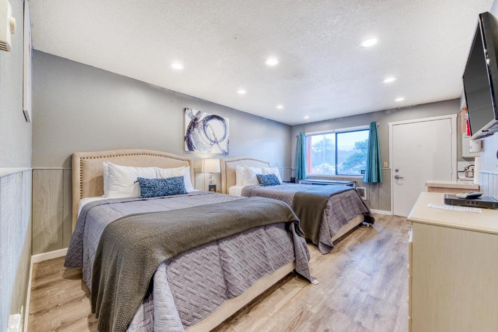 a bedroom with two beds and a television in it at Sea Treasures Inn #104 in Rockaway Beach