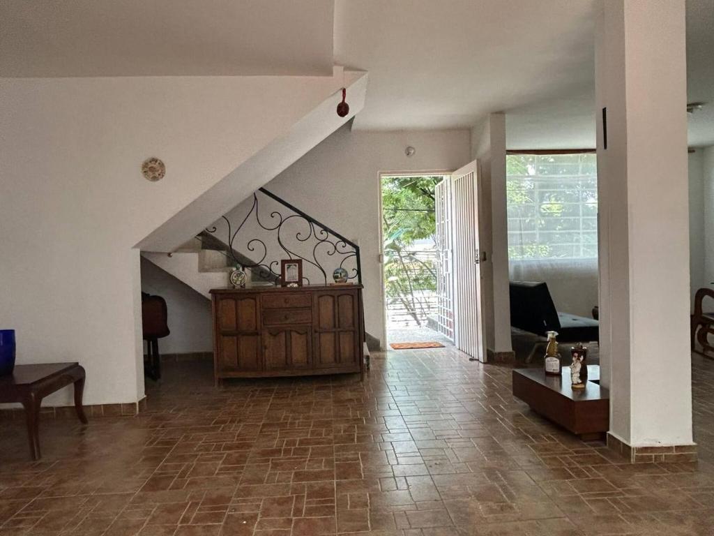 a living room with a staircase and a table and a couch at The Cats Nail house in Cali