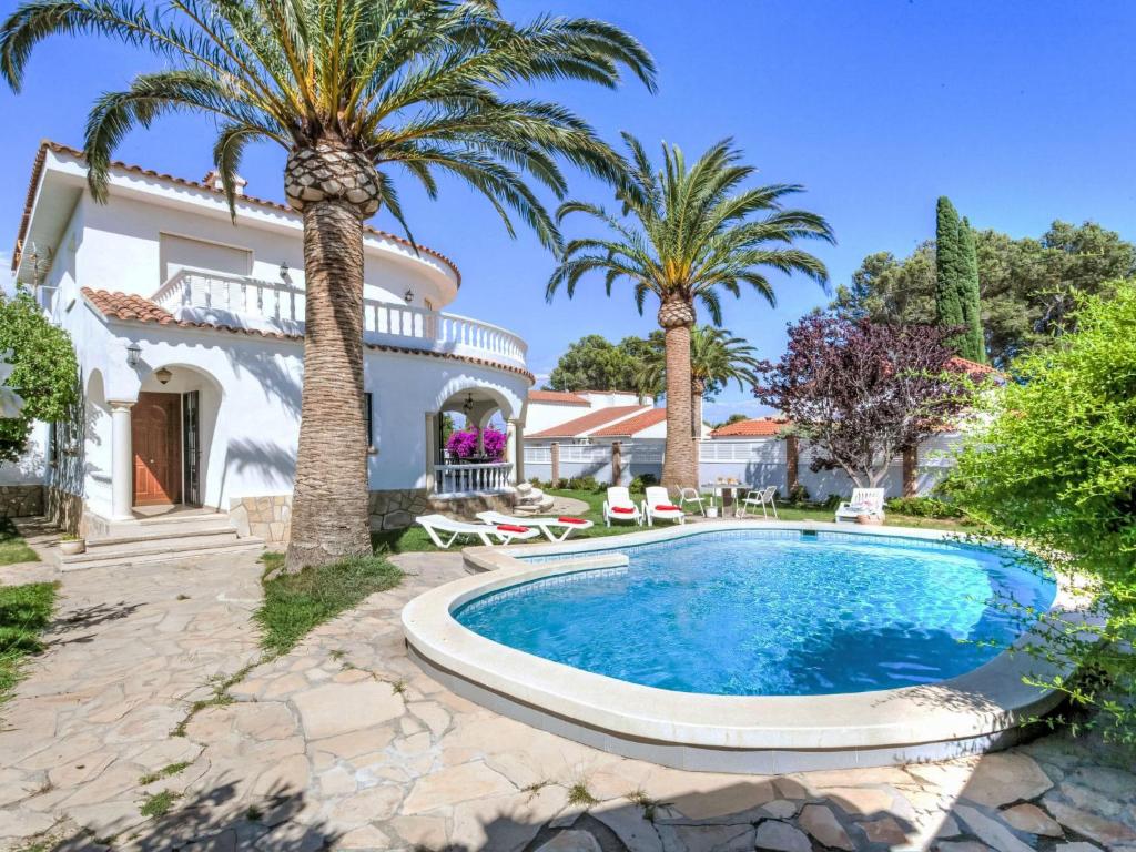 a villa with a swimming pool and palm trees at Villa Villa Mar by Interhome in Miami Platja
