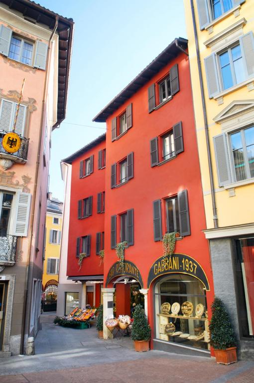 a red building with a bakery in front of it at Suite Apartments by Hotel Gabbani in Lugano