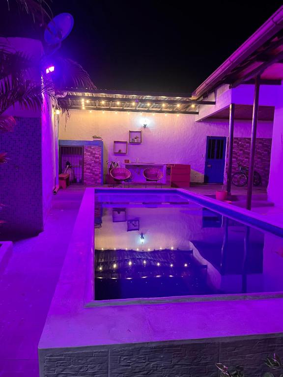 a swimming pool lit up at night with purple lights at Casa vacacional SAMUEL in Honda