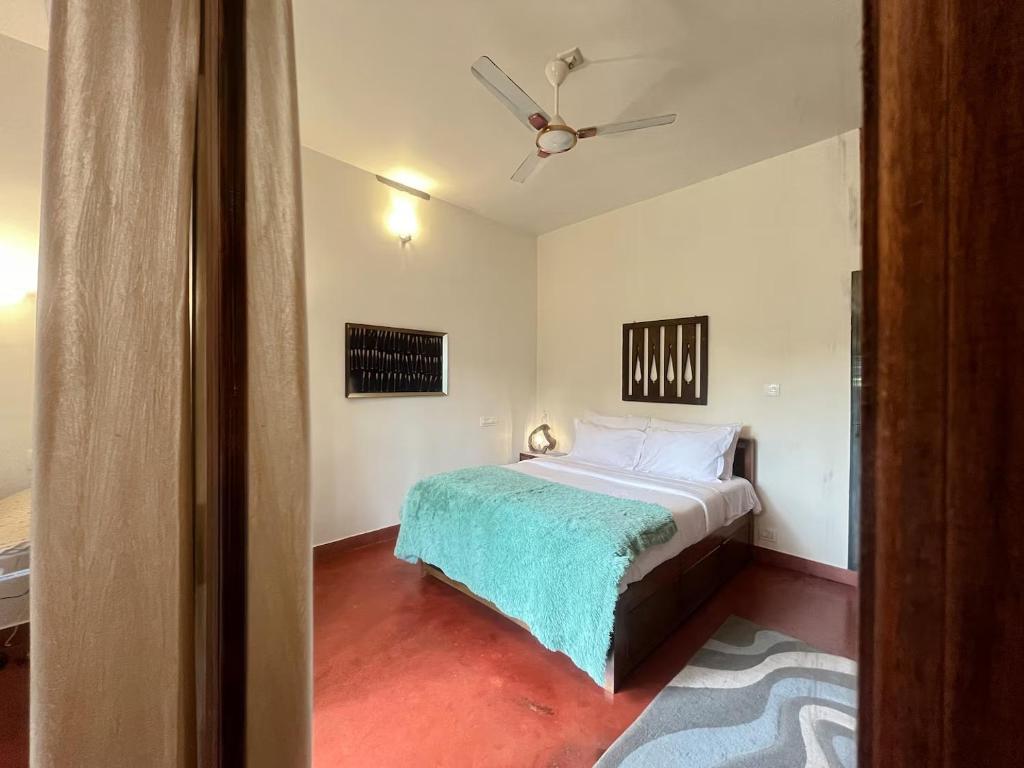 a bedroom with a bed and a ceiling fan at House StoneHaven in Kaniyāmbetta