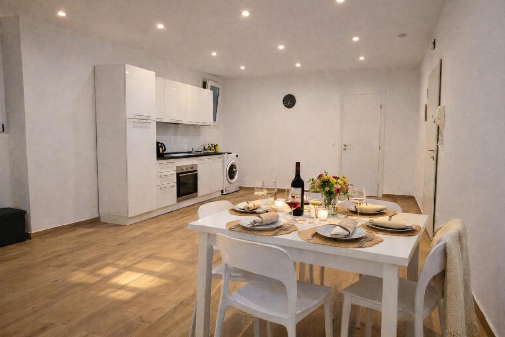 a kitchen and dining room with a white table and chairs at Maison TRENCA - fully equiped apartment in Menton