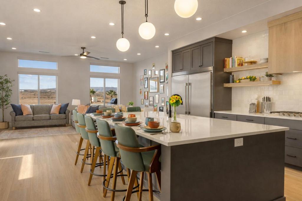 a kitchen with a long bar with chairs and a table at Terra Rossa townhouse in St. George