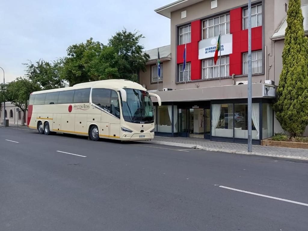 a white bus parked in front of a building at Cumberland Hotel & Conference Centre Worcester in Worcester