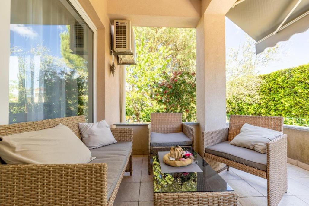 a porch with a couch and chairs and a table at Apartment Vidak in Vantačići