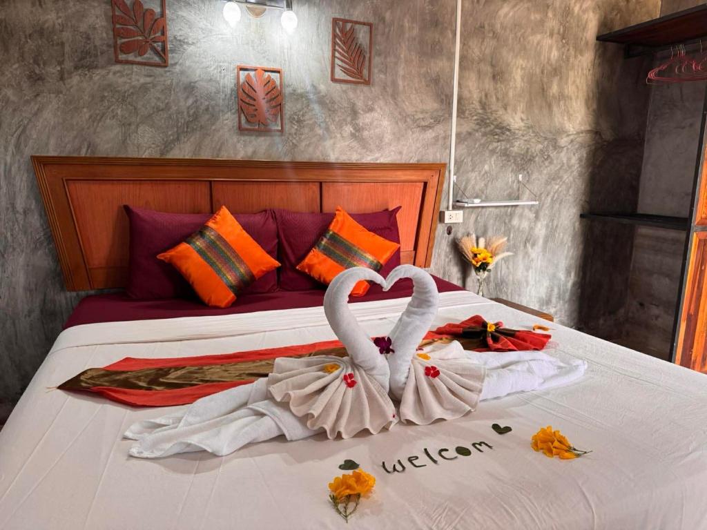two swans made out of towels on a bed at Lanta natural hut garden in Ko Lanta