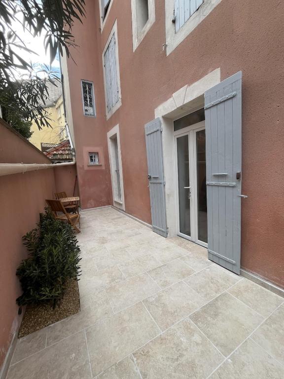 an empty courtyard of a building with two doors at Cocon de Nuit - appartement RDC, avec terrasse in Orange