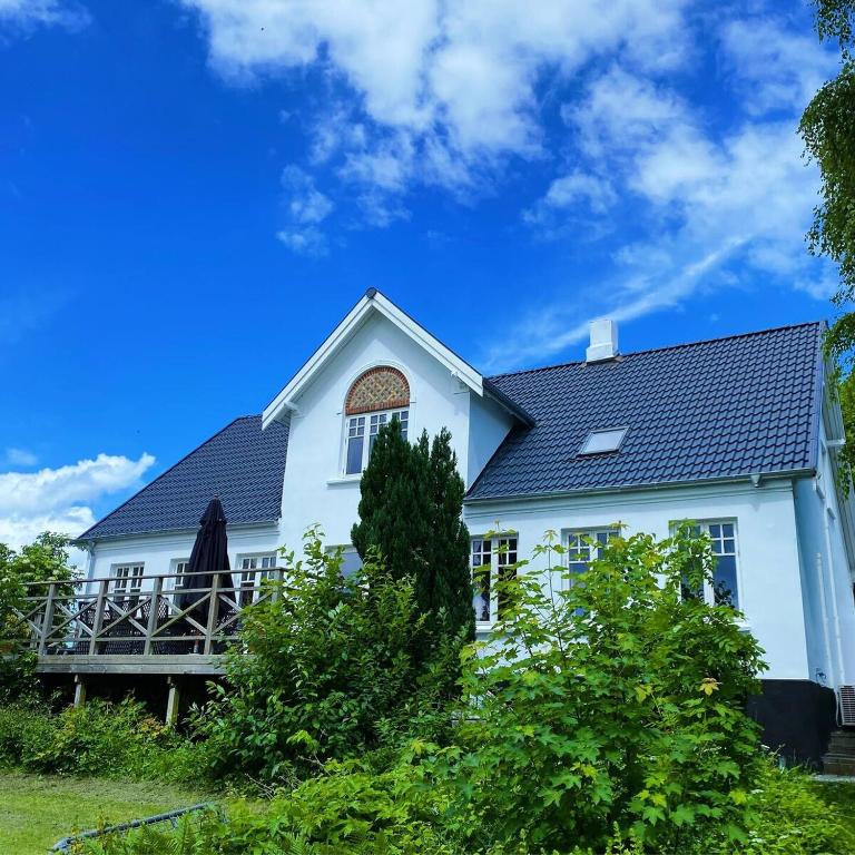 a white house with a black roof at Farmhouse in idyllic settings in Ærøskøbing