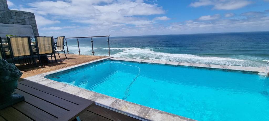 a swimming pool with a view of the ocean at Dolphin Wave in Mossel Bay