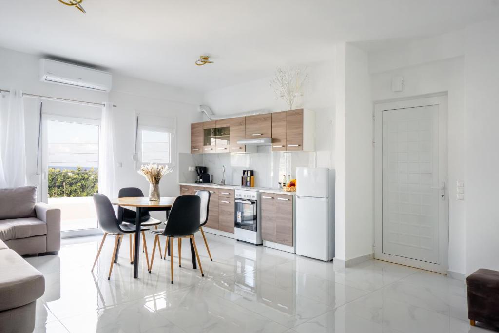 a kitchen with white appliances and a table and chairs at Atrium The Living Experience in Malia