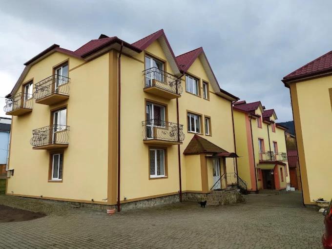 a large yellow building with balconies on a street at Вілла Верховина in Skhidnitsa