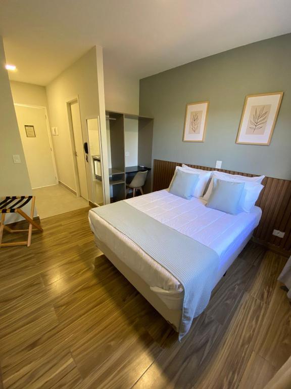 a bedroom with a large bed with white sheets at NOBRE HOTEL COTIA in Cotia