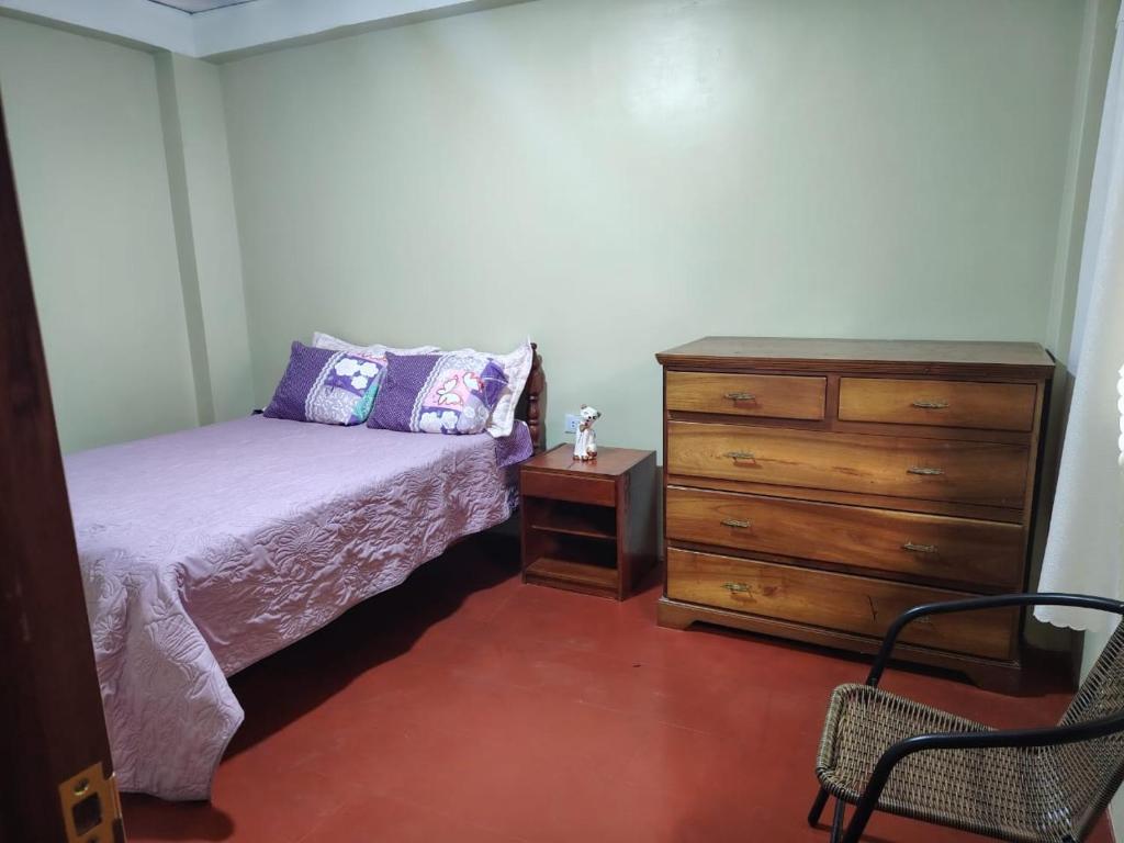 a bedroom with a bed and a dresser at Posada del Carmen 2 in Quillabamba