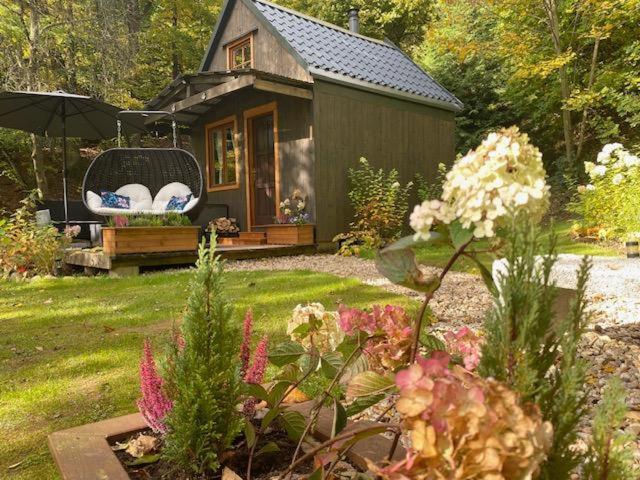 a small house with a chair in a yard at Tiny Resort Chotěvice 2 in Chotěvice