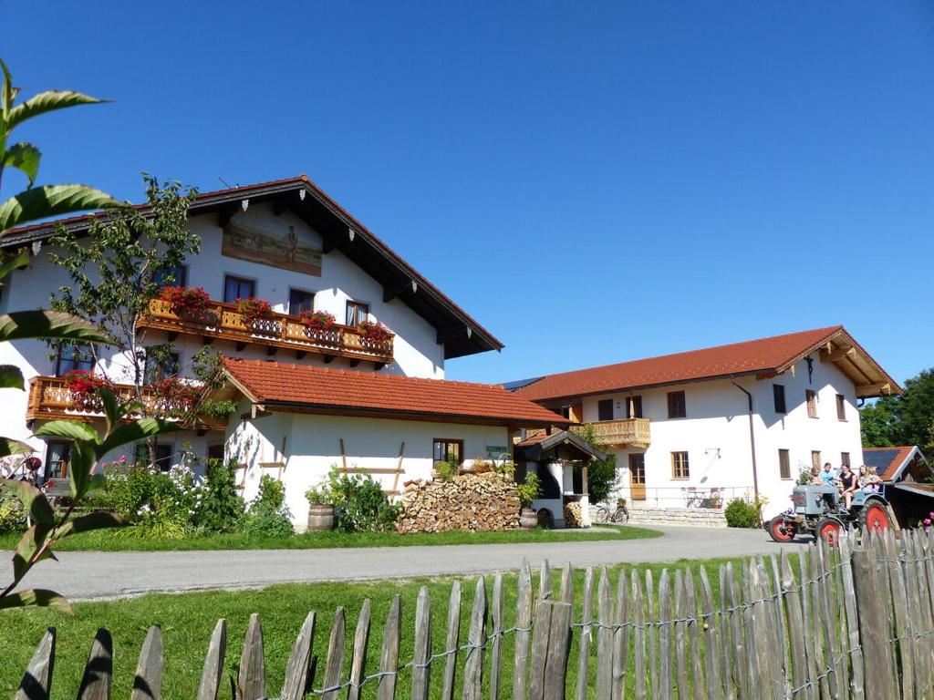 a white building with a fence in front of it at Schauerhof in Chieming