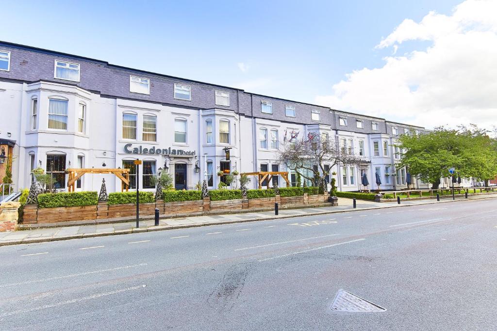a row of white buildings on the side of a street at Caledonian Hotel in Newcastle upon Tyne