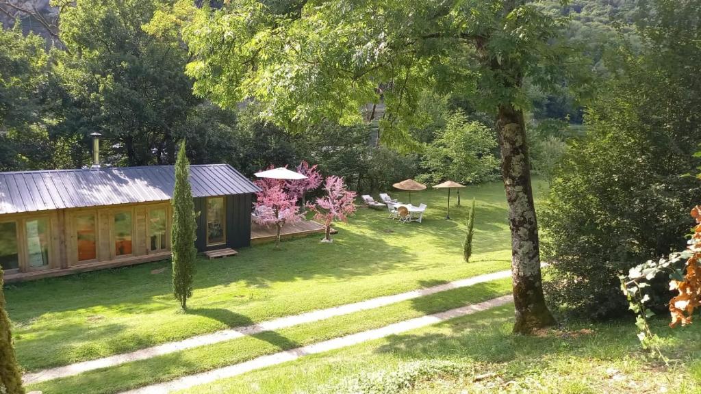 a house in the middle of a yard with trees at CHALET de la CHEVANNE in Laissey