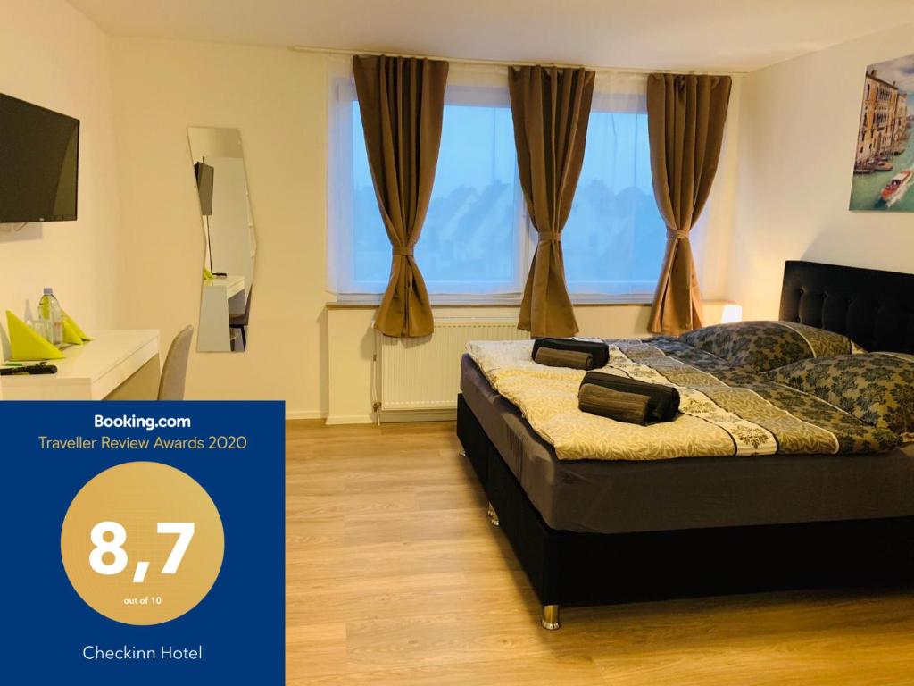 ein Schlafzimmer mit einem Bett vor einem Fenster in der Unterkunft Checkinn Hotel in Bad Salzuflen