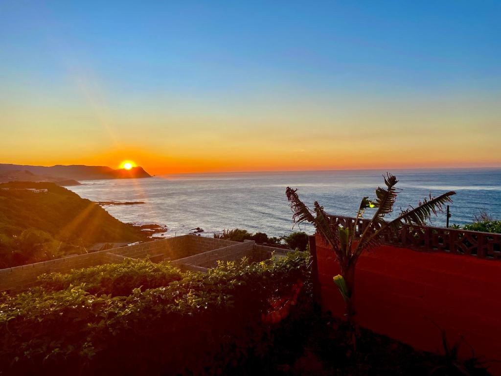 a sunset over the ocean with the sun setting at Jabula Beach House in Mngazana