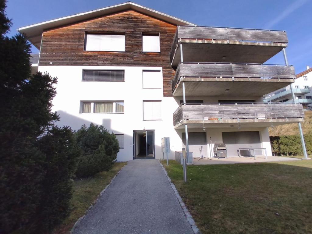 a white building with a walkway in front of it at Apartment Keller in Savognin