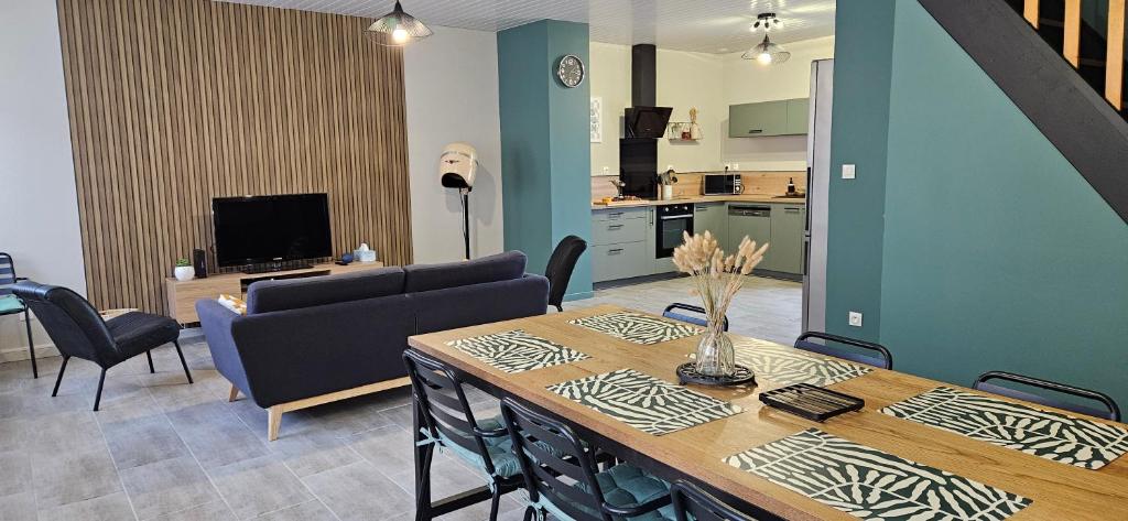 a living room with a dining table and a kitchen at Gite Les 4 Moustaches in Bourbourg