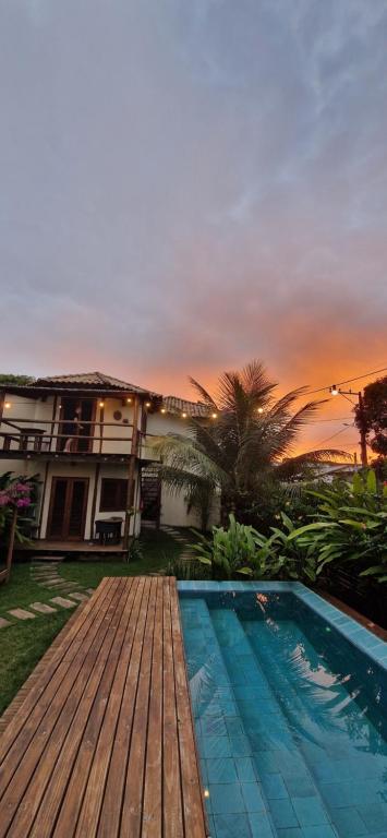 a swimming pool with a wooden deck and a house at Vila Cacau pousada - Serra Grande in Serra Grande