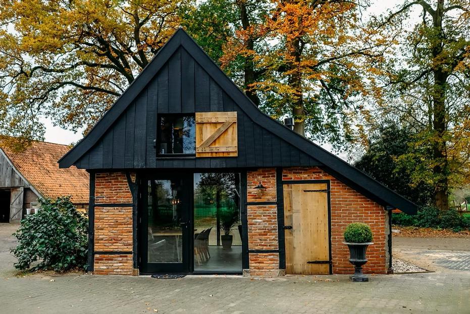 a small house with a black roof at Vakantiewoning Lemselermaten in Weerselo